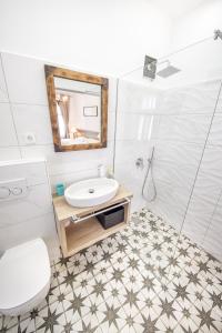 a bathroom with a toilet, sink, and bathtub at OH Apartments & Rooms in Ljubljana