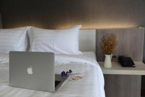 a laptop computer sitting on top of a bed at Socool Grand Hotel in Nang Rong