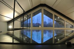 Habitación con ventana grande y mesa de cristal. en La Maison Contemporaine, en Namur