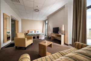 una camera d'albergo con divano e letto di Hotel der Freiraum a Güssing