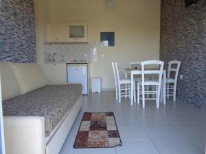 a room with a bed and a kitchen with a table and chairs at Porto Panorama in Porto Heli