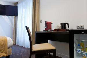 um quarto de hotel com uma secretária e uma cadeira em Simon's Boutique Hôtel em Paris