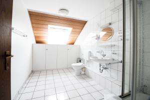 a bathroom with a toilet and a sink at Hotel Zum Eisenhammer in Oberhausen +47 photos