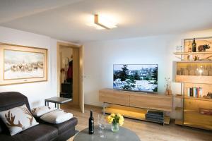 een woonkamer met een bank en een flatscreen-tv bij Appartement Zill in Tux