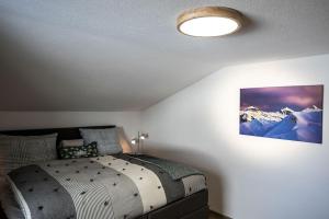 a bedroom with a bed with a mountain picture on the wall at Appartement Zill in Tux