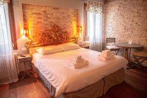 a bedroom with a large bed with towels on it at Rosso Charm B&B in Venice