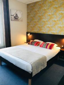 una camera da letto con un grande letto con due cuscini di Hotel Bellevue a Brest