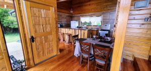 a kitchen with a table and chairs in a cabin at Cabana Chiloe in Queilén +14 photos