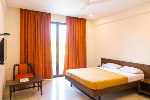 a hotel room with a bed and a window at Hotel Dreamland in Pune