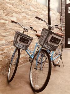 two bikes with baskets parked next to a brick wall at Hello Guesthouse in Lugang