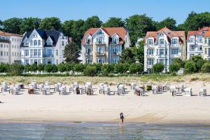 a person standing in the water on the beach at Strandhotel Möwe in Bansin