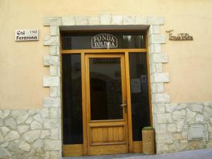 a front door of a building with a sign above it at Fonda Toldra in Ulldemolins