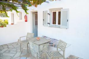 patio ze stołem i krzesłami oraz oknem w obiekcie Themonia w mieście Apollonia