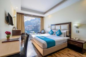 ein Hotelzimmer mit einem großen Bett und einem Fenster in der Unterkunft Snow Valley Resorts Shimla in Shimla