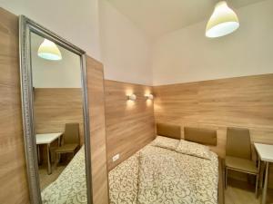 a room with a bed and two tables and a mirror at Невеликі апартаменти-смарт в центральній частині біля ТЦ Магнус in Lviv