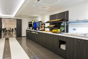 uma cozinha com armários pretos e um balcão com comida em Simon's Boutique Hôtel em Paris