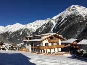 ein Gebäude im Schnee mit Bergen im Hintergrund in der Unterkunft A CASA Aquamarin in Sölden