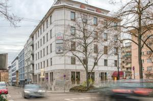 ein Gebäude auf einer Straße, an der Autos vorbeifahren in der Unterkunft Centro Hotel Sautter in Stuttgart