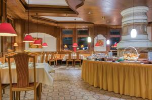 シュトゥットガルトにあるCentro Hotel Sautterのテーブルと椅子のあるレストラン、ビュッフェ