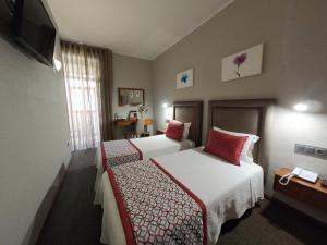 Uma cama ou camas num quarto em Lusitana Hotel