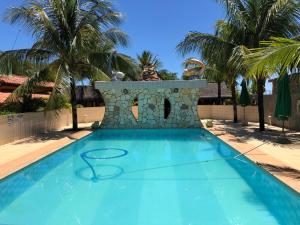 Arenápolis的住宿－Pousada Capyvara，一个带喷泉和棕榈树的蓝色游泳池
