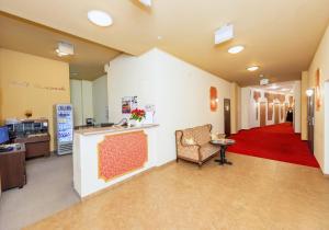 a lobby of a hospital with a chair and a red carpet at Hotel Marczewski in Bielsko-Biala