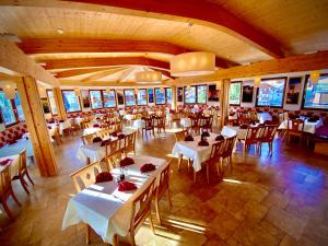 une salle à manger avec des tables et des chaises blanches dans l'établissement Hotel Komperdell, à Serfaus