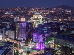 uma vista de uma cidade à noite com um edifício em Hotel Slavija em Belgrado