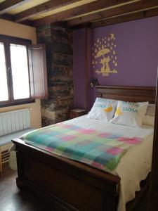 a bedroom with a bed with a colorful blanket on it at Luna de Vilar in Vilarpescozo