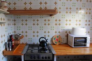 a kitchen with a stove and a microwave at Casa Mediterranea en pueblo de mar in Cala Figuera