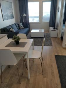 ein Wohnzimmer mit einem weißen Tisch und Stühlen in der Unterkunft Kotimaailma Apartments Siljotie in Rovaniemi