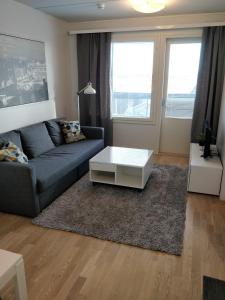 ein Wohnzimmer mit einem Sofa und einem Couchtisch in der Unterkunft Kotimaailma Apartments Siljotie in Rovaniemi