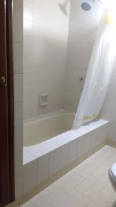 Baño blanco con bañera y lavamanos en Chalet Microcentro Tandil en Tandil