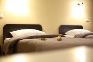 2 camas en una habitación de hotel con una fruta en la cama en Готель "Палац" en Okhtyrka