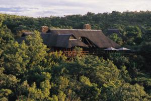 a house in the middle of a forest at Makweti Safari Lodge in Welgevonden Game Reserve