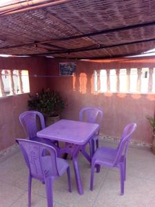 a purple table and chairs on a patio at Elmenzah Apartments in Taroudant