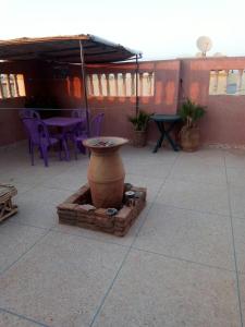a large vase on a patio with a table and chairs at Elmenzah Apartments in Taroudant