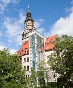 a building with a clock tower on top of it at Philippus Inklusionshotel Leipzig in Leipzig