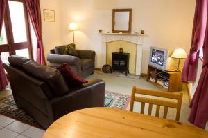 a living room with a couch and a fireplace at Nethercote Cottage, Seven Springs Cottages in Cheltenham