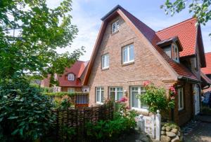 une maison en briques avec un toit rouge dans l'établissement Ferienhaus Meerweh Sylt, à Westerland