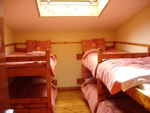 a room with three bunk beds and a window at Killarney Railway Hostel in Killarney