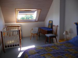 Gîte du pré de la dame في Férel: غرفة نوم بسرير وكراسي ونافذة