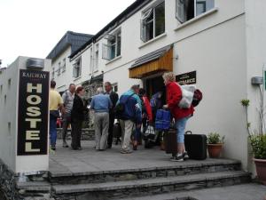 un grupo de personas parados fuera de un edificio en Killarney Railway Hostel, en Killarney