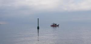 a boat in the water with a pole in the water at Apartmani Val in Pula