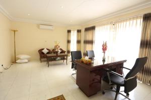 ein Wohnzimmer mit Schreibtisch und Tisch mit Stühlen in der Unterkunft Eastern House in Dhaka