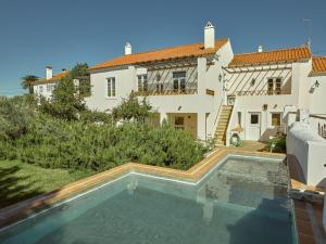 a house with a swimming pool in front of a house at Casas da Estação, Country Houses in Marvão