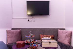 a living room with a couch with a tv on the wall at Rodia in Volos