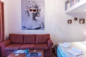 una sala de estar con sofá y una foto de una mujer en Rodia, en Volos