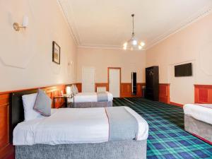 スターリングにあるLost Guest House Stirlingのベッド2台とテレビが備わるホテルルームです。