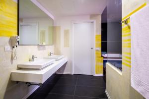 a bathroom with two sinks and a mirror at Motel Autosole Vip in Castelnuovo Scrivia